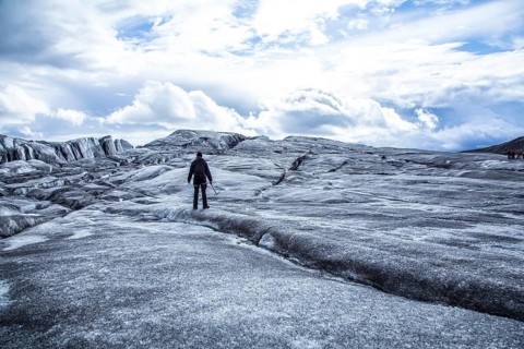 A young man on her back with booties and hammer on the trekking of the Svinafellsjokull glacier. Iceland