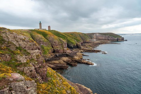 The beautiful coastline next to the Phare Du Cap Frehel is a maritime lighthouse in Cotes-dÂ´Armor France . At the tip of Cap Frehel