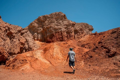 A man tourists walking white salt of Badwater Basin alerted by extreme heat