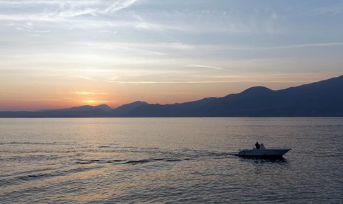 Single motorboat sailing on Lake Garda at Torri del Benaco