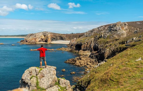 A young man in a red shirt on the coast enjoying the summer at Le Chateau de Dinan on the Crozon peninsula in French Brittany