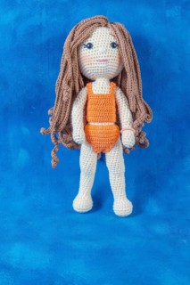 Close-up of a handmade amigurumi doll on a blue background