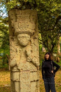 A woman in to detail of a figure in The temples of Copan Ruinas. Honduras
