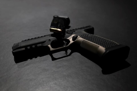Modern Elegant Handgun and Charger with Bullet on Grey Background in Switzerland