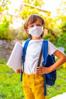 Caucasian child with face mask ready for back to school. New normality