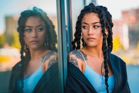 Urban session. Young woman of black ethnicity with long braids and with tattoos