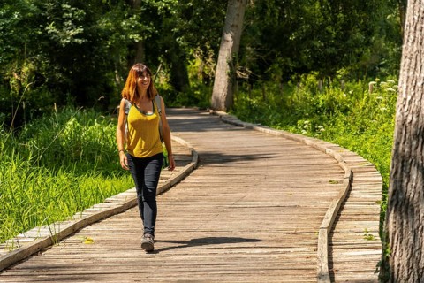 A young woman trekking on the footpath along a footbridge between La Garette and Coulon