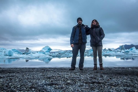 A couple with a backpack looking at the Jokulsarlon Ice Lake in the golden circle of southern Iceland