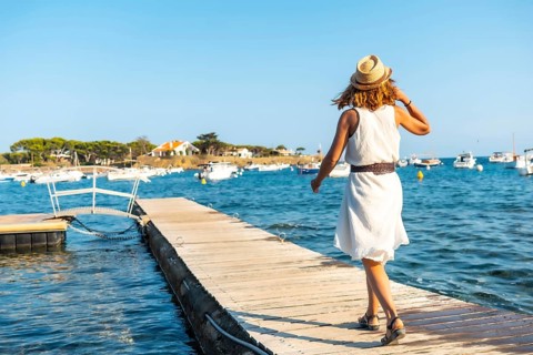 A young woman in a dress in Cadaques walking along the sea