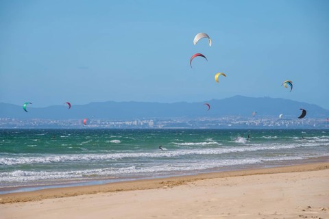 Kiteboarding kitesurfing kiteboarder kitesurfer kites on the Atlantic ocean beach at Fonte da Telha beach