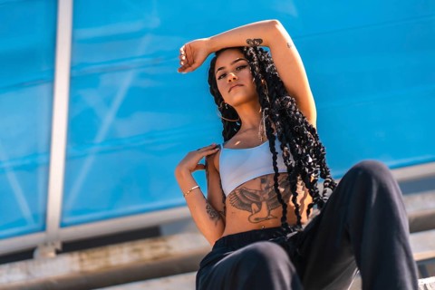 Young black woman with long braids and tattoos