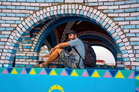 A young tourist sitting on a beautiful terrace of a traditional blue house in a Nubian village along the Nile river and near the city of Aswan. Egypt