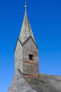 Tower of the Chapel of St. Nicholas and St. Magdalene with many wooden shingles in Linsen near Niedersonthofen