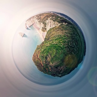 Sightseeing panoramic view to the Falaise d'Aval limestone cliffs as a micro planet in space. La Manche waters and continental side of Etretat