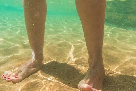 A young woman walking on a beautiful sandy seabed in the town of Zarautz very close to San Sebastian