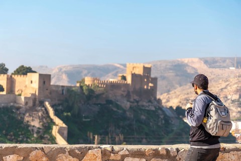 A young tourist at the viewpoint of Cerro San Cristobal de la Muralla de Jairan and the Alcazaba the town of Almeria