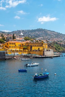 Small fishing boats next to the Forte de Sao Tiago on the beach of Funchal