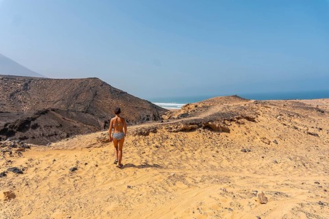 A young woman on a path of the wild beach Cofete of the natural park of Jandia