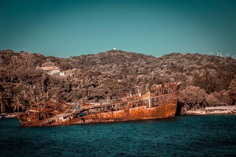 Boat with abandoned rock in the port of Roatan. Honduras