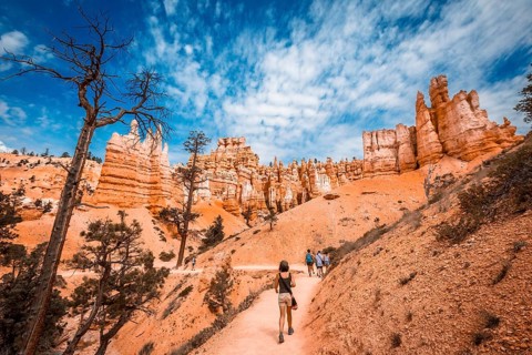A young woman walking along the giant eroded stones on the Queens Garden Trail