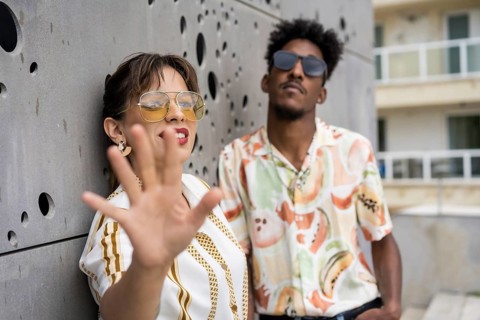 Woman gesturing stop while posing happily with a stylish man in the street