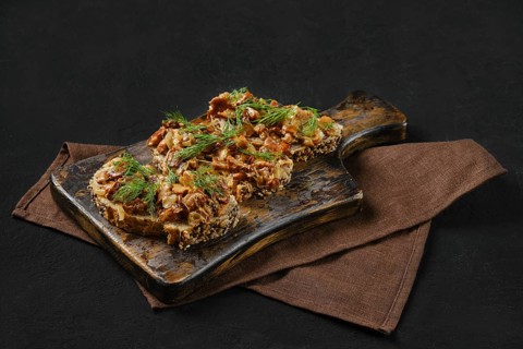 Sandwich with chanterelle mushrooms on black background