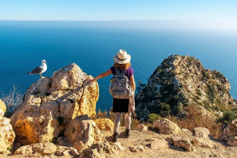 A young hiker at the Mirador de Carabineros in the Penon de Ifach Natural Park in the city of Calpe