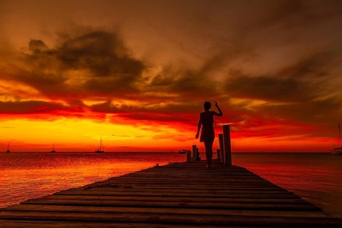 A young woman walking in the sunset on West End beach in Roatan