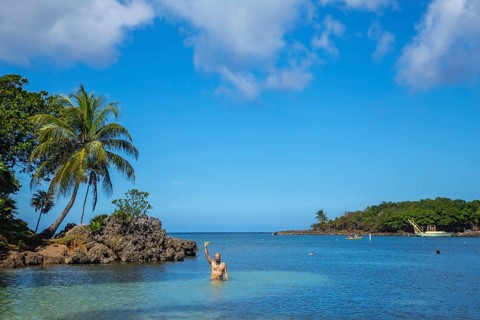 A young man entering the Caribbean Sea at West End Beach on Roatan Island. Honduras