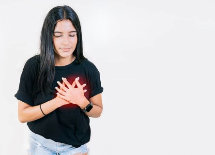 Young woman with tachycardia. Concept of people with heart problems. Latin woman with heart pain on isolated background
