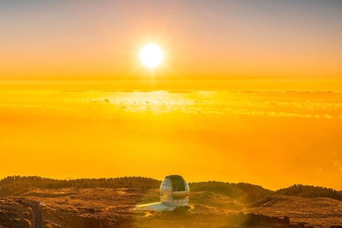 Large Canary Telescope called Grantecan optico del Roque de los Muchachos in the Caldera de Taburiente in a beautiful orange sunset