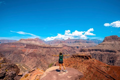 A young woman on a viewpoint of the South Kaibab Trailhead trekking. Grand Canyon