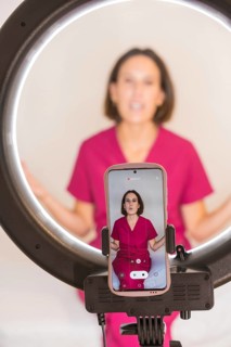 Vertical photo of a nutritionist woman filming video with the mobile phone