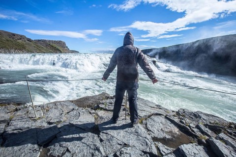 A young man above the Gullfoss waterfall in the golden circle of the south of Iceland