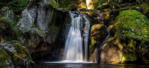 Waterfall in autumn forest with rocks