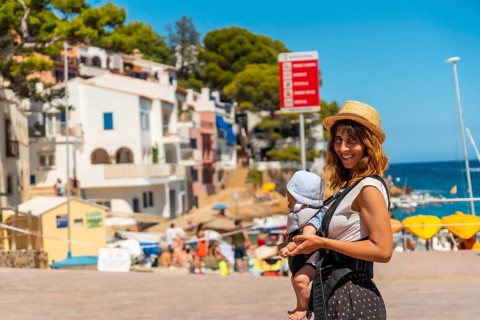 A mother with her baby on the beach of Sa Tuna on the coast of Begur in summer