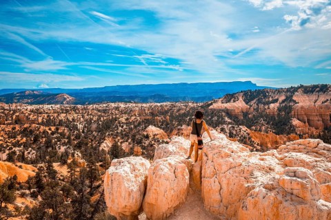 A girl sitting looking at the views from the Sunrise Point in Bryce National Park. Utah