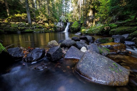 Waterfall in autumn forest with rocks