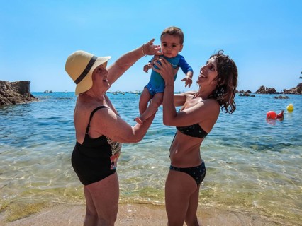 A family having fun in the summer in Cala Canyet next to the town of Tossa de Mar. Girona