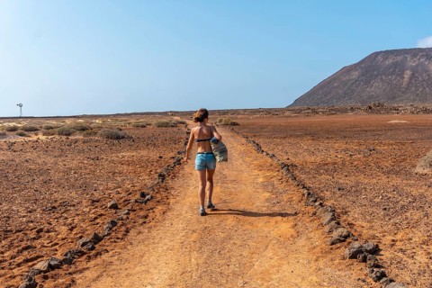 A young tourist girl walking the trails of Isla de Lobos
