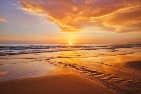 Atlantic ocean sunset with surging waves at Fonte da Telha beach