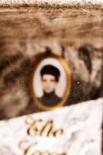 Spider's web on a tombstone in front of a blurred photo Medailion of the deceased in a cemetery