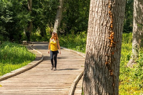 A young woman trekking on the footpath along a footbridge between La Garette and Coulon