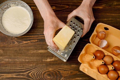 Male hands using grater for cheese