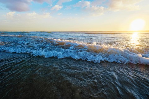 Atlantic ocean sunset with surging waves at Fonte da Telha beach