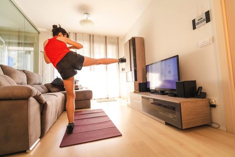 A young woman doing sports in her living room. Sport in the quarantine at home