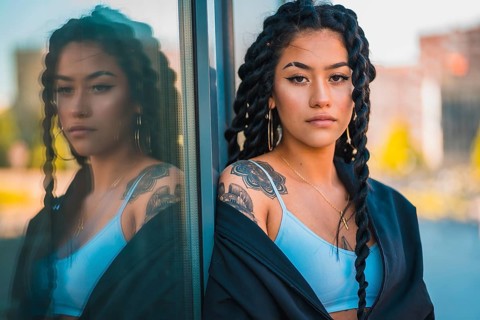 Urban session. Young woman of black ethnicity with long braids and with tattoos