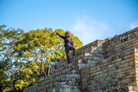 A young girl watching The ball game field in the temples of Copan Ruinas. Honduras