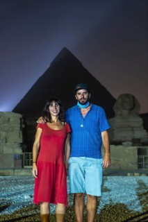 A tourist couple at the sound and light show at the beautiful pyramids and sphinx of Giza. Night in the city of Cairo. Africa