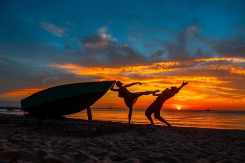 A couple playing at Roatan Sunset from West End. Honduras